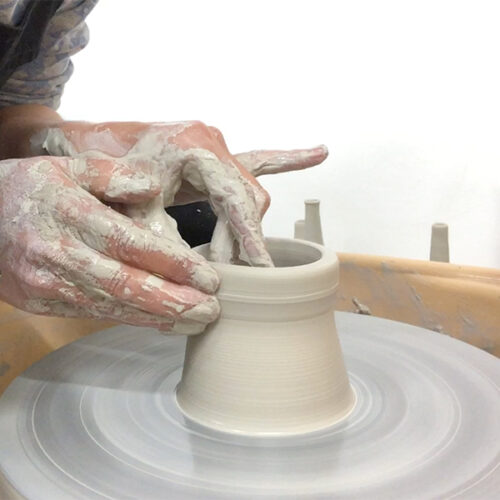 niho pulling a cylinder on the pottery wheel
